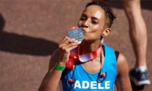 Adele Roberts kissing her medal after finishing a marathon.