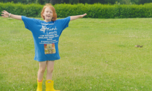 Alba Stodgen posed in a field, in her signature yellow wellies.