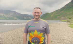 Gary McKee posed on a beach, smiling.