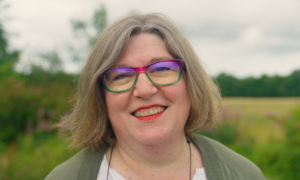 Lois Wolffe stood in a field, smiling at the camera.